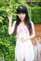 A woman in a white dress posing for a picture.