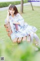 A woman sitting on a bench in a park.