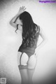 A woman in lingerie and stockings posing for a picture.