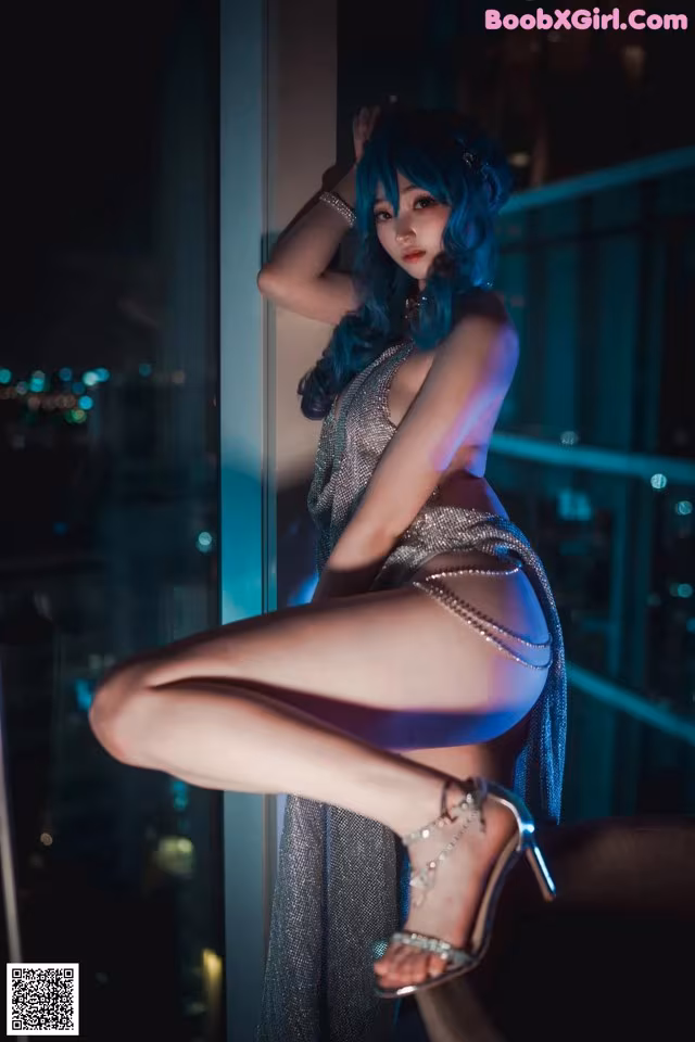 A woman in a silver dress posing on a balcony.