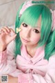 A woman with green hair holding a flower in her hand.