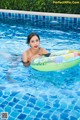 A woman in a swimming pool with an inflatable ring.