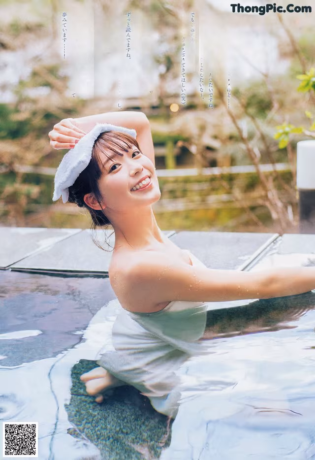 A woman in a white dress sitting in a pool of water.