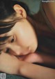 A young girl laying on the floor with her eyes closed.